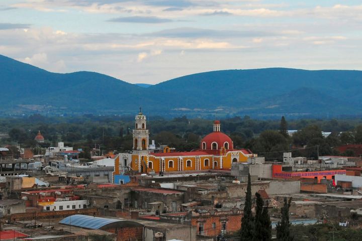 a large building with a mountain in the background